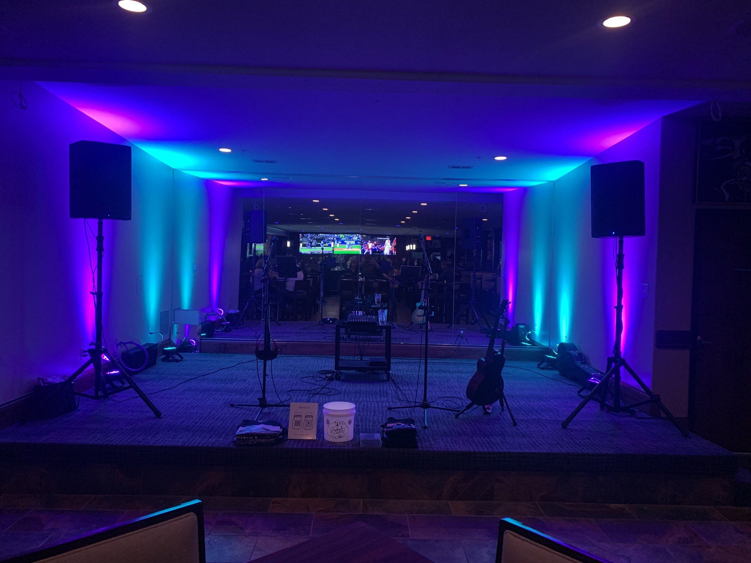 A stage at a Big Day event, washed in cyan and purple uplighting